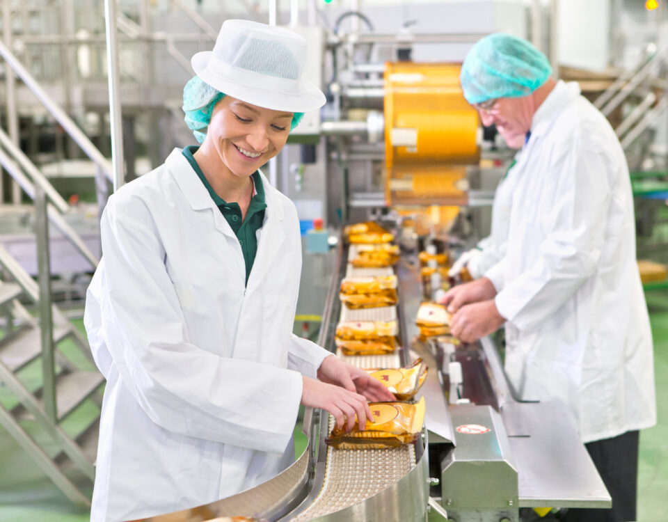 workers smiling while holding packed foods